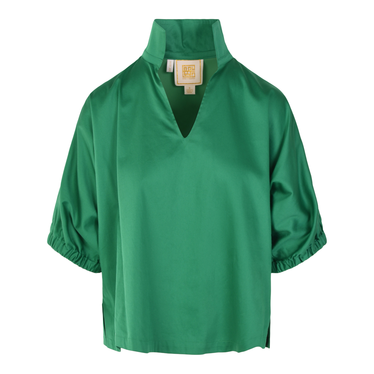 The Poppy Top is a green cotton poplin blouse with a loose fit, short sleeves gathered at the hem, a high collar and V-neckline. A beige label is visible inside the collar.