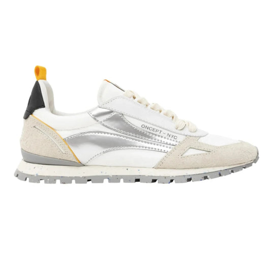 Introducing the Toronto Silver Splash Sneakers, a chic white shoe enhanced with suede accents and gleaming metallic silver elements. Enjoy ultimate comfort and support thanks to its lightweight construction, which includes a textured sole, "ONCEPT - NYC" branding on the side, and eye-catching yellow and black heel tabs.