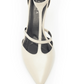 The Crawford Heel - Beige Lizzard is an elegant high-heeled shoe featuring a pointy toe in off-white leather with thin T-straps across the arch. The black insole displays white branding, and the stiletto heel is photographed from above on a white background.