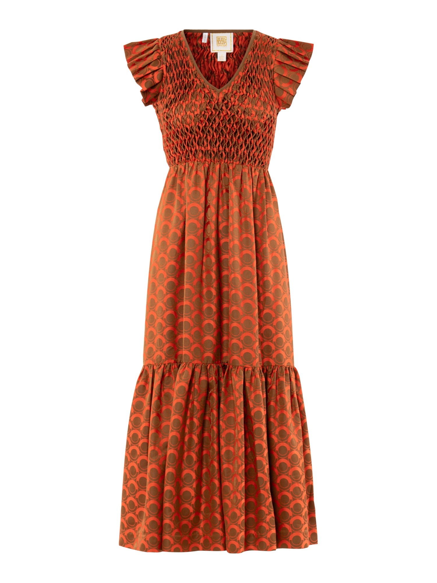 The Grace Maxi dress features a rust hue, ruffled cap sleeves, smocked bodice, V-neckline, flared skirt, and a semi-circle dark-on-rust pattern inspired by vintage Italia style.