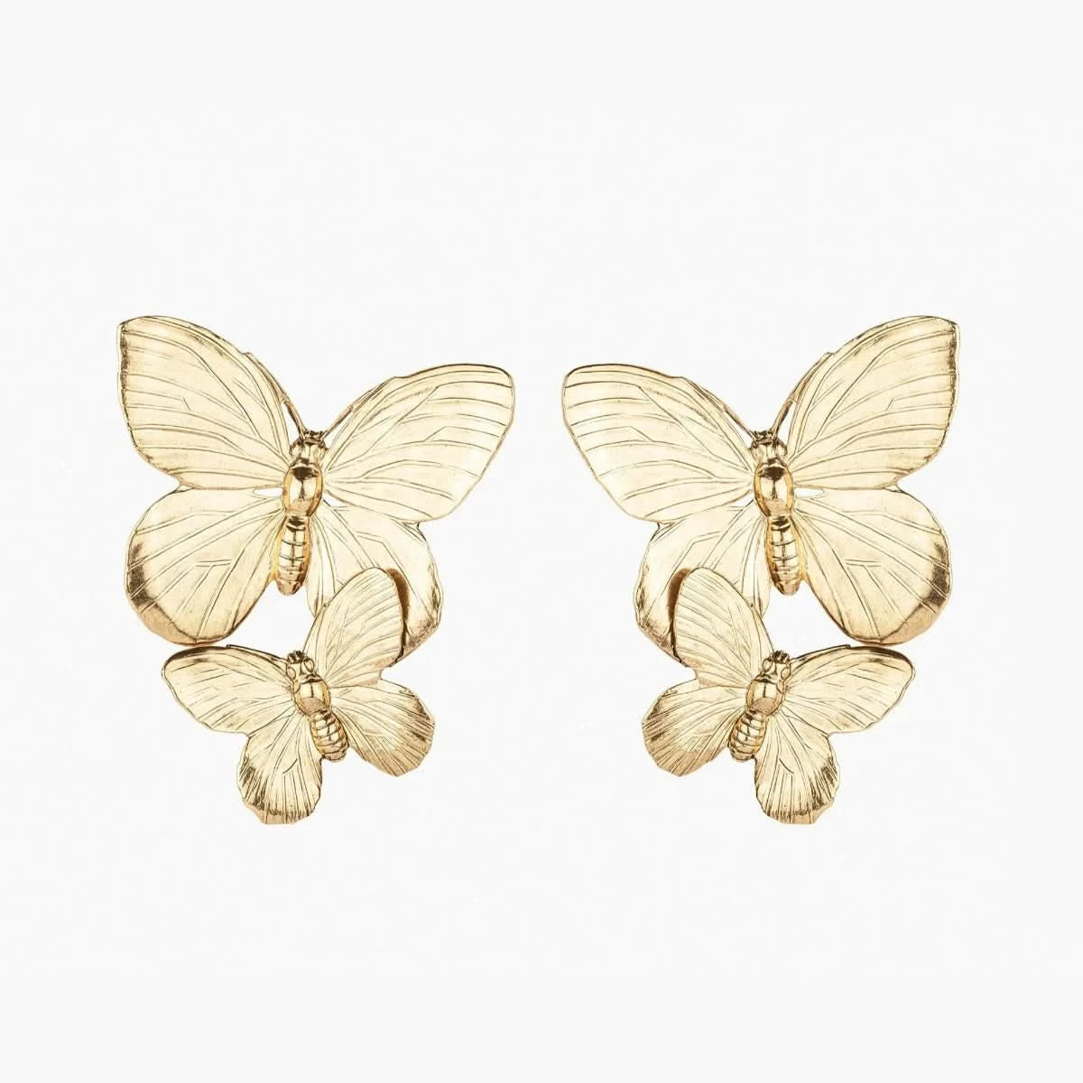 Explore our Papillon Earring - Gold, wearable art featuring intricately crafted butterflies, with a larger one elegantly perched on top and a smaller one beneath. These popular gold pieces stand out against a white background, blending sophistication with playful charm.