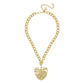 The Gold Scalloped Leaf Chain necklace features a gold chain embellished with a prominent, textured leaf-shaped pendant. This exquisite piece includes an adjustable clasp and a small round tag, showcasing elegance and charm.