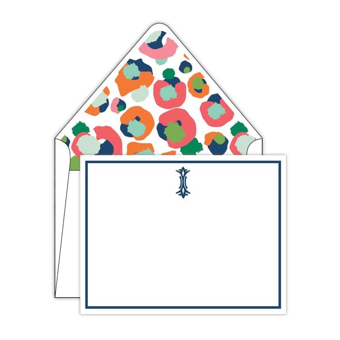 Introducing the Gift Bar - Multi Spot Cheetah Social Sets, a collection of elegant note cards that come with envelopes featuring a vibrant abstract floral pattern. The cards are plain white and accented with a blue border, complemented by a small decorative monogram emblem at the top center to add a personalized touch to your correspondence.