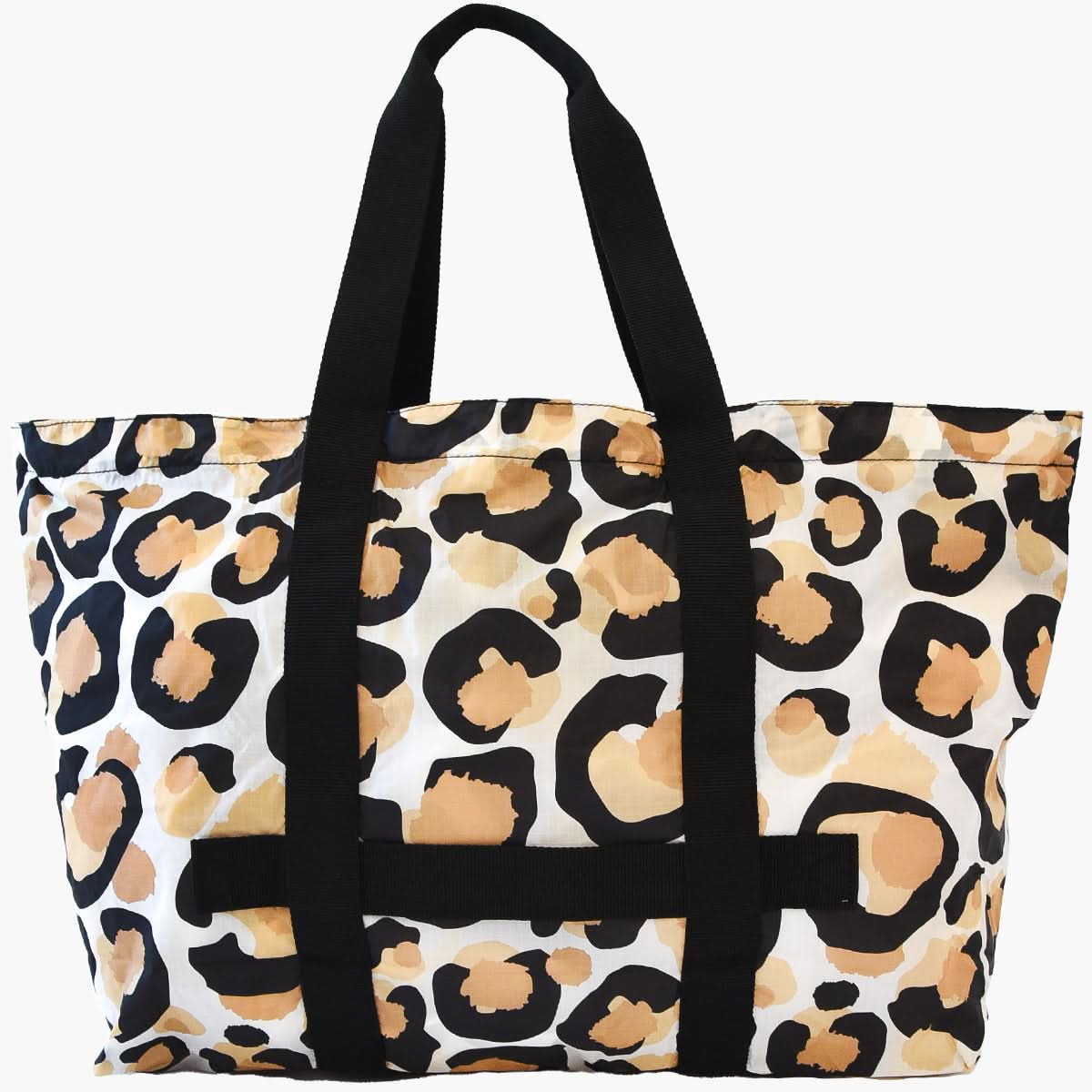 Introducing the Travel Tote - Classic Spot Cheetah, a spacious companion with sleek black handles and a striking leopard print pattern. This design features bold, irregular spots in shades of brown, tan, and black on a crisp white background, making it perfect for your stylish adventures.