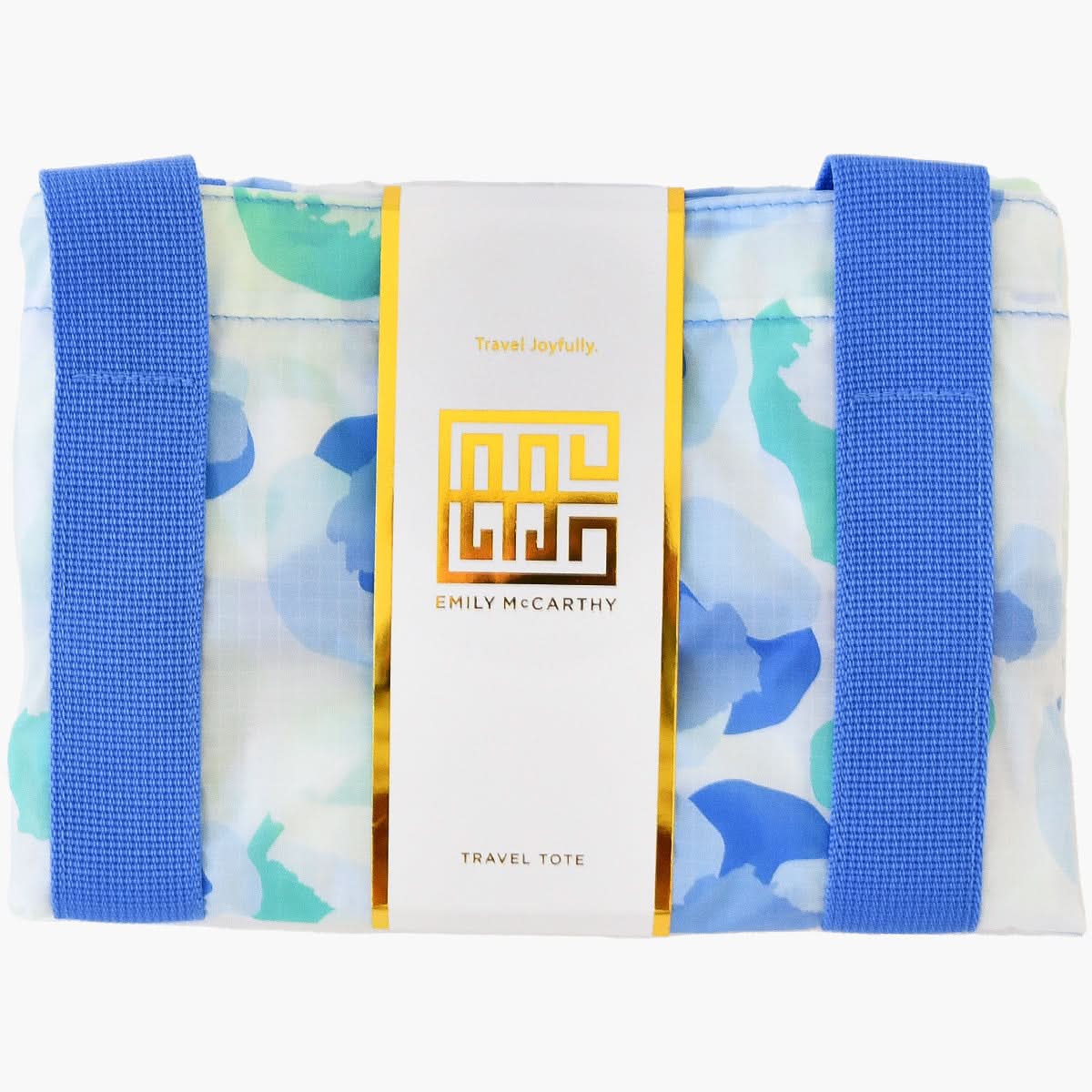 This Travel Tote - Seaglass Spot Cheetah features a vibrant blue and green abstract pattern, accented by two durable blue straps. The sophisticated white label is adorned with gold and black text that reads "Emily McCarthy Travel Tote," perfect for those who desire to travel with joyful style and Spot Cheetah elegance.
