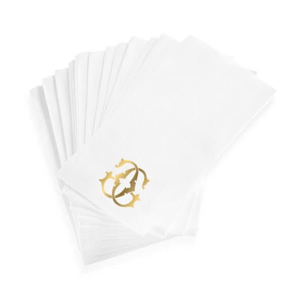 A stack of 1-Letter Monogrammed Guest Towels made from white linen-textured paper, each decorated with a gold monogram or ornate design in one corner.