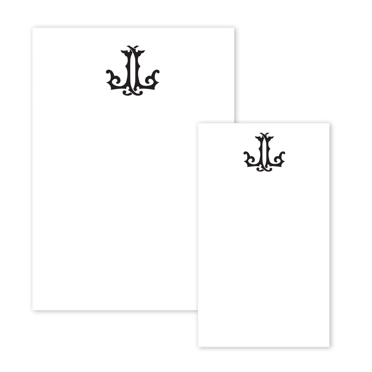 The Gift Bar Notepad Set includes two sheets of white paper showcasing an ornate, black decorative design at the top center that resembles a stylized, symmetrical emblem. These sheets are positioned side by side like pages from a crisp white notepad, with the left sheet larger than the right, featuring elegant lettering.