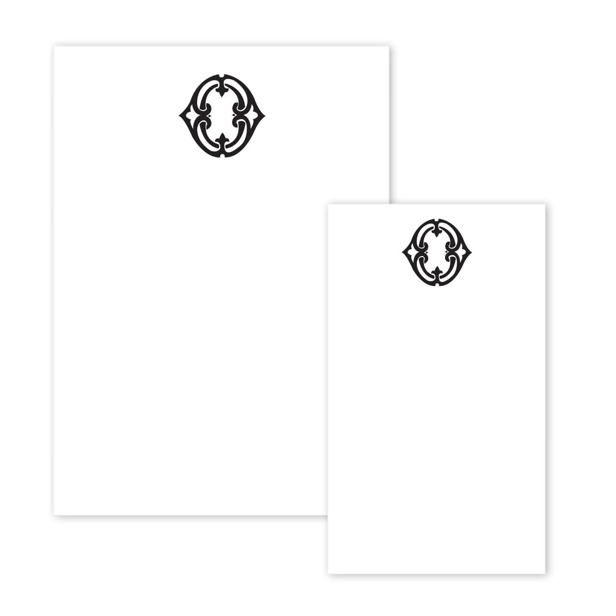 The Gift Bar Notepad Set consists of two white sheets of paper, one larger than the other, each adorned with an intricate black decorative emblem at the top. The symmetrical design features curved lines in a circular pattern, set against an elegantly plain background.