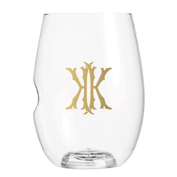 The 1-Letter govino® Stemless Shatterproof Wine glass is a clear, reusable wine glass adorned with a gold decorative pattern on the front. It features an ergonomic indentation on one side, ensuring a comfortable grip.