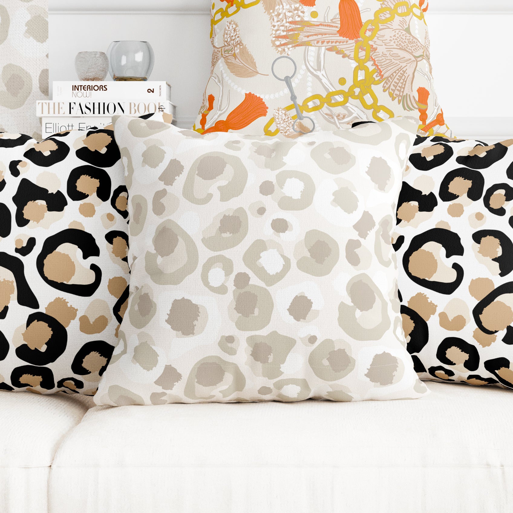 Create a cozy living room setup with a white sofa embellished with three stylish throw pillows made from Fabric by the Yard - Neutral Cheetah. These pillows feature captivating leopard, geometric cheetah print, and abstract designs in neutral and orange tones. Enhance the chic atmosphere by placing a stack of fashion books in the background.