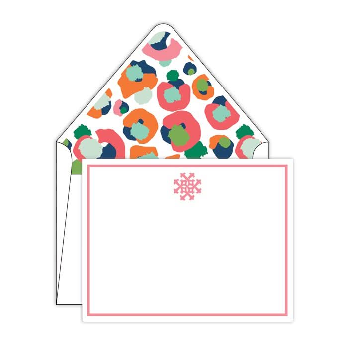 A notecard from the "Gift Bar - Multi Spot Cheetah Social Sets," featuring a pink snowflake design at the top and a monogrammed pink border, sits next to an open envelope. The liner reveals a colorful abstract pattern with circles in shades of pink, blue, and green.