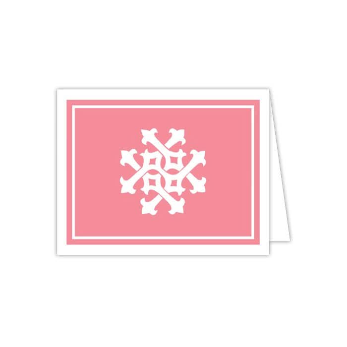 The Gift Bar - Folded Note showcases a white, abstract snowflake design on its pink cover. It is part of a set containing 10 notecards with matching envelopes and is displayed partially open to reveal its pristine white interior accompanied by a delicate white border around the snowflake.