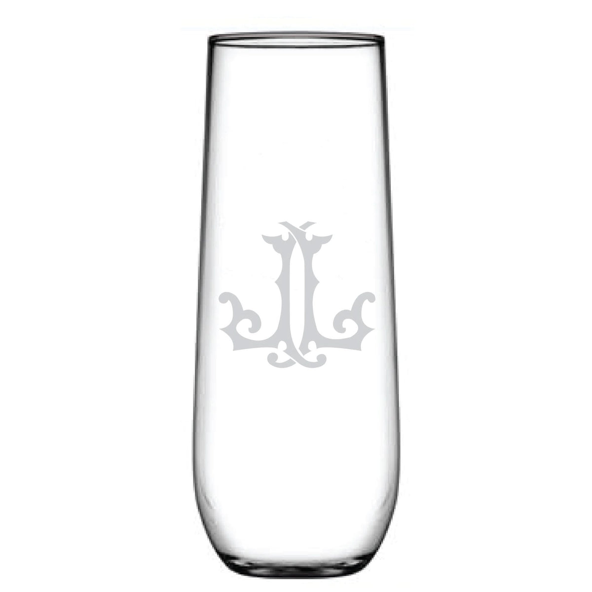A tall, clear glass named 1-Letter Monogrammed Stemless Champagne Flute features an ornate, decorative etched design resembling a monogram or emblem. The cylindrical shape tapers slightly at the top.