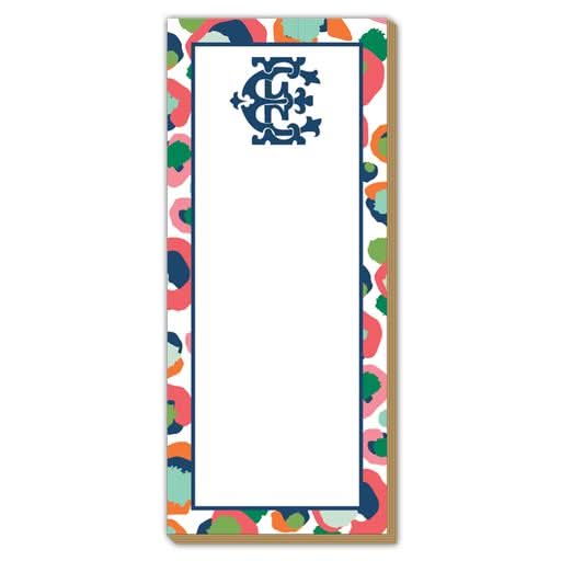 The Gift Bar - Luxe Skinny Pad is a rectangular notepad measuring 3.5 x 8.5 inches, made from 100# card stock, and features a decorative border with vibrant abstract patterns in orange, pink, green, and blue. Its blank white interior is embellished with a blue ornamental design at the top center.