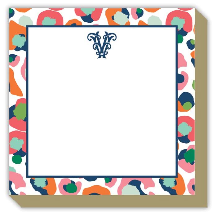The Gift Bar - Mini Luxe Notepad is a 4x4 white square pad with a blue W monogram on top and a colorful abstract border featuring orange, pink, green, and navy spots. Includes 100 sticky sheets.