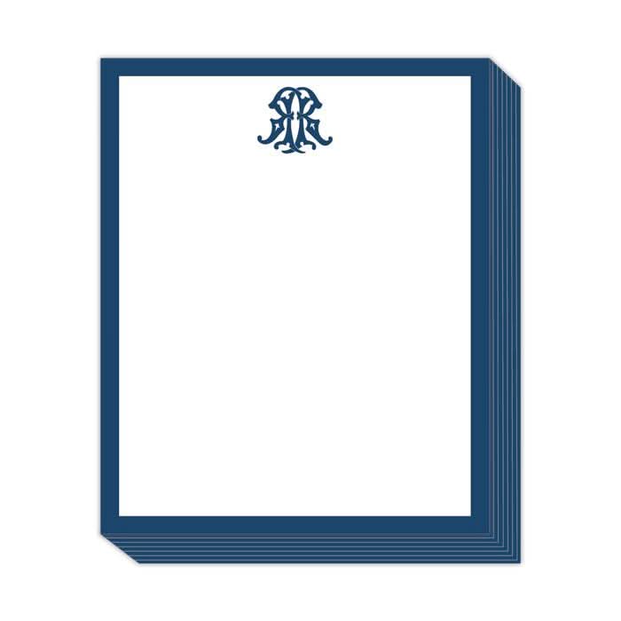 The Gift Bar - Short Stack Pad features a 5.25 x 6.5" set of elegant stationery, adorned with a dark blue border and a decorative monogram at the top center of each page. Its clean, minimalistic design emphasizes the monogram and border beautifully on text weight sheets.